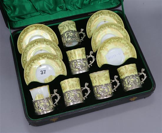 A cased yellow ground porcelain and silver mounted coffee set